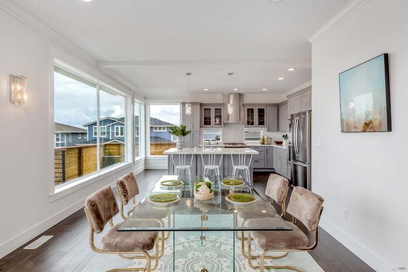 Modern open-concept kitchen and dining area featuring dark LVP flooring. Image courtesy of Oscar Surfaces.
