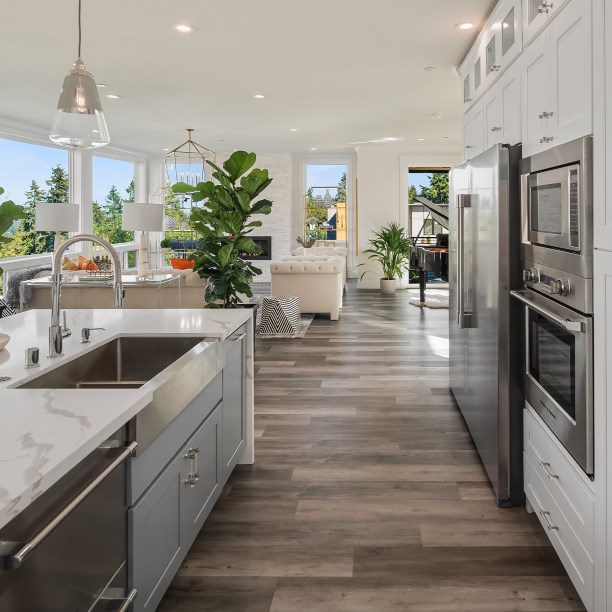 Luxury vinyl plank flooring installed throughout a bright open-concept kitchen and living space.
